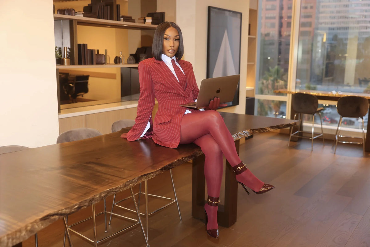 Personne inerte en costume rouge assise à une table dans un bureau moderne